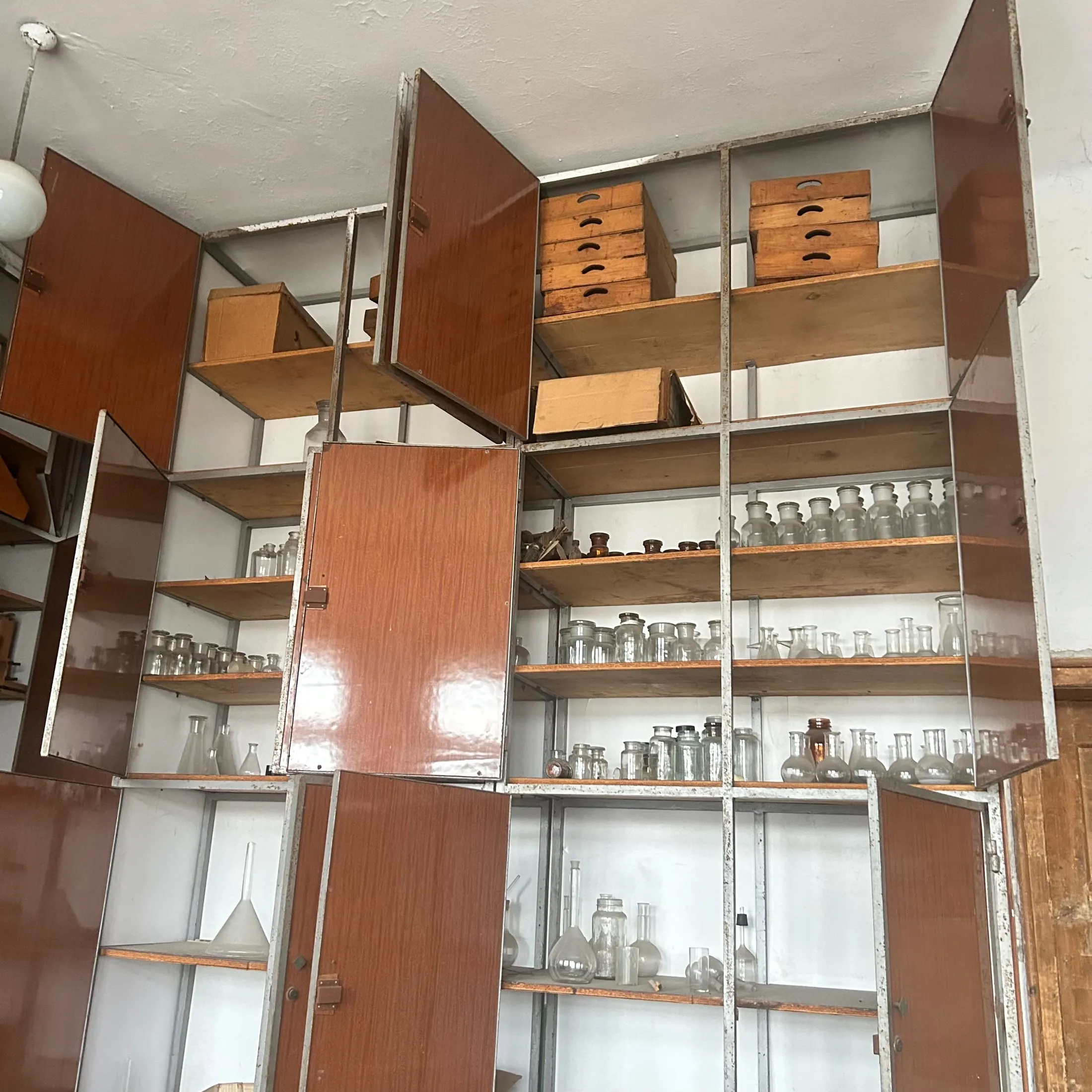 Шкафове в кабинета по химия, пълни с колби, епруветки и стъкленици